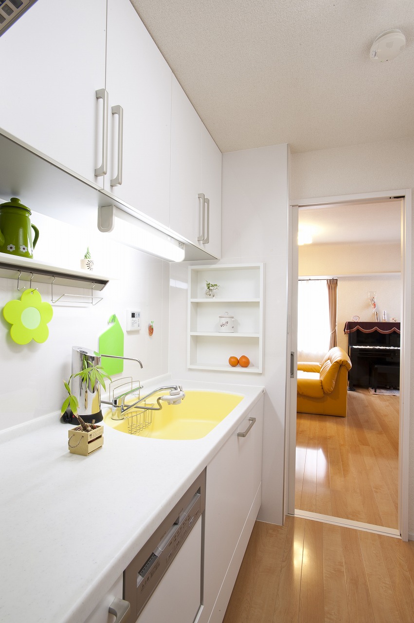キッチンはイエローのシンクのものをセレクト。 壁の厚みを利用したニッチ収納が便利。